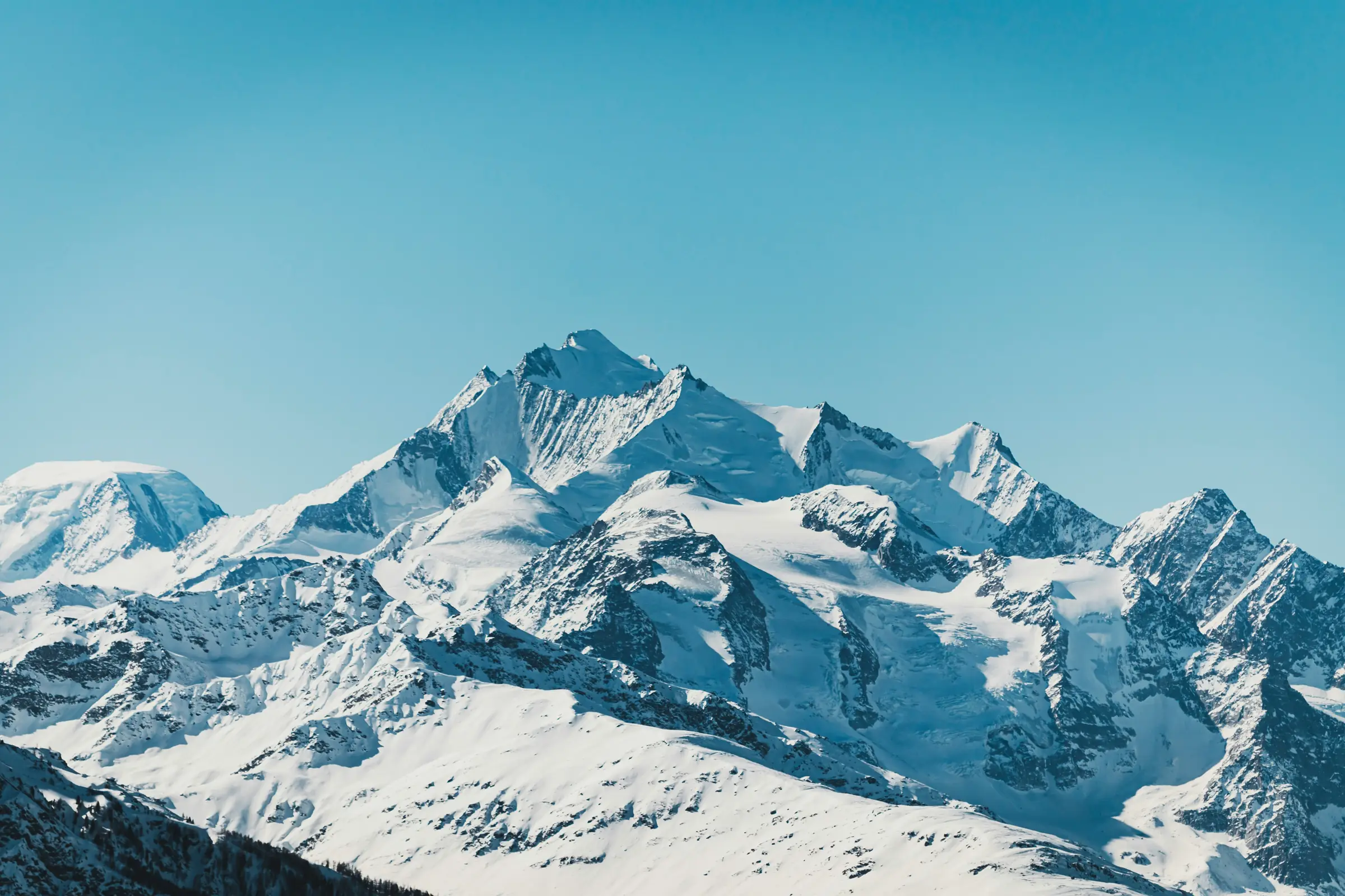 A wide glaciated massif under a clear blue sky
