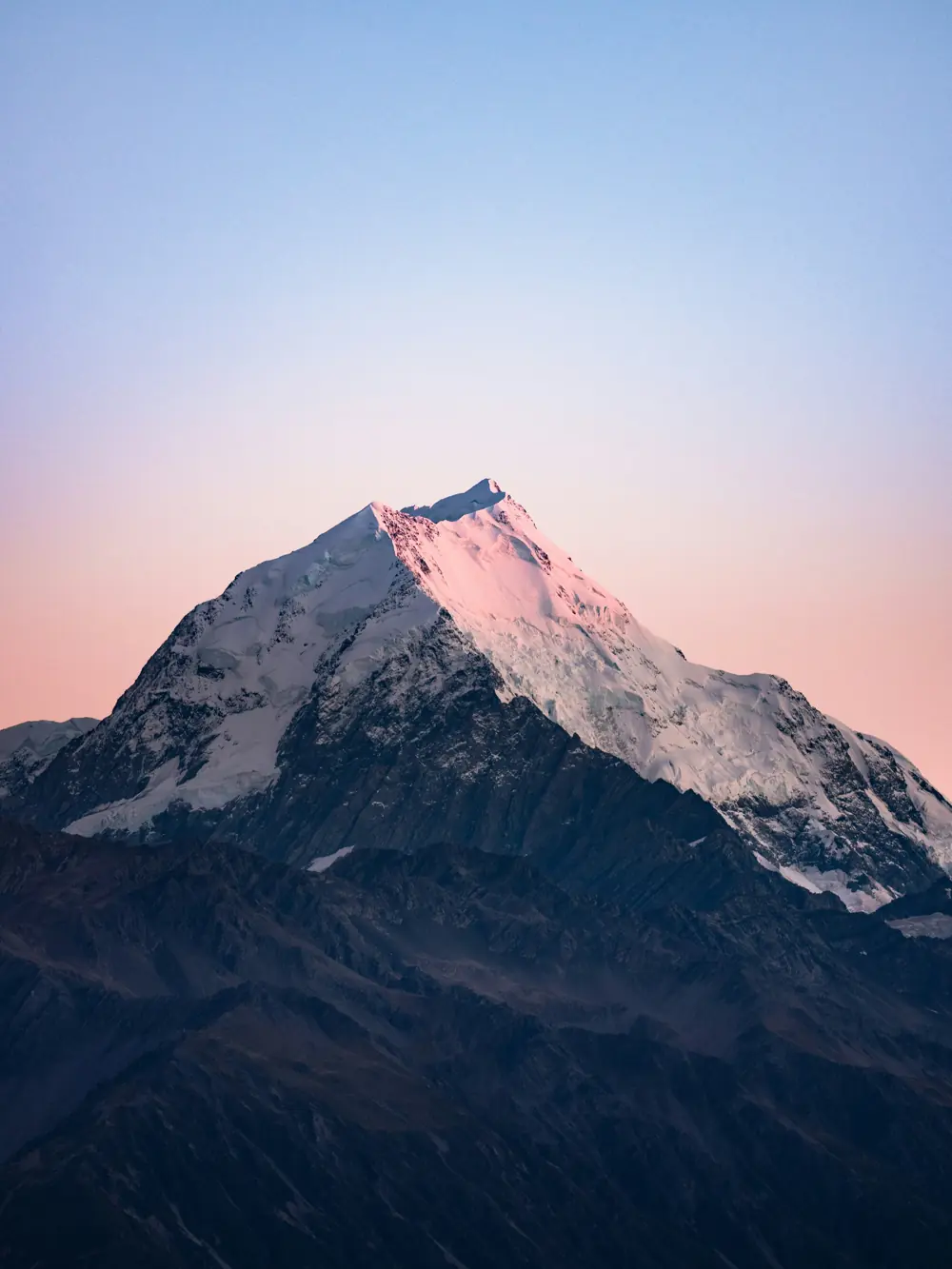 A lone snow peak lit pink at dawn
