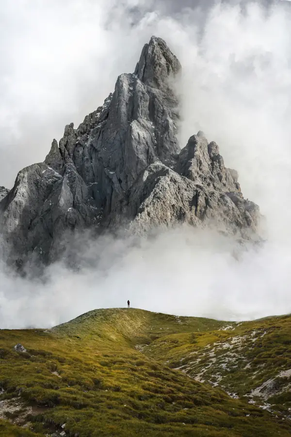 A sharp rock spire rising out of cloud